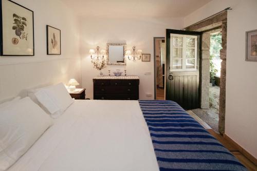 a bedroom with a bed and a dresser and a mirror at Cottage São Veríssimo 