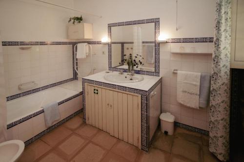 y baño con lavabo, bañera y espejo. en Cottage São Veríssimo 