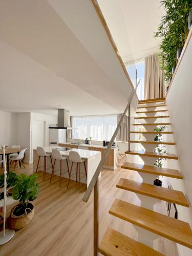 a staircase in a living room with a table and chairs at Casas Capela by O'Porto Seven in Ferral