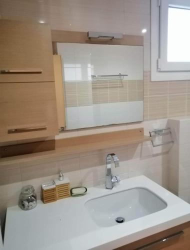 a bathroom with a white sink and a mirror at Breathtaking sea view in Kavála