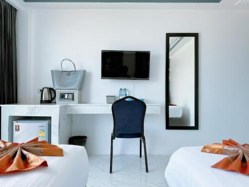 1 dormitorio con 2 camas, espejo y silla en Machorat Aonang Resort at Aonang Beach Krabi, en Ao Nang Beach