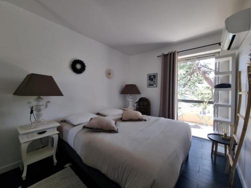 una camera con due letti e una finestra di Superbe appartement avec Rooftop privé a Saint-Tropez