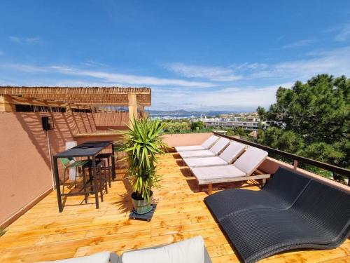 patio con sedie bianche e tavolo sul tetto di Superbe appartement avec Rooftop privé a Saint-Tropez