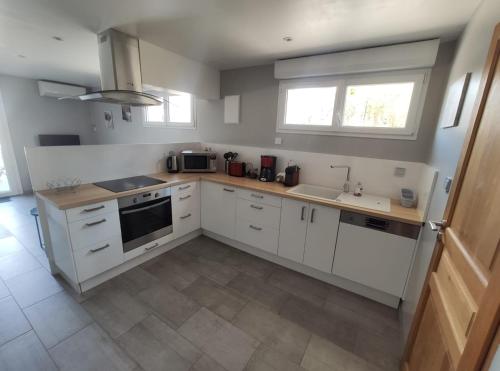 a kitchen with white cabinets and a sink and a stove at L'Ansolane in Fuveau