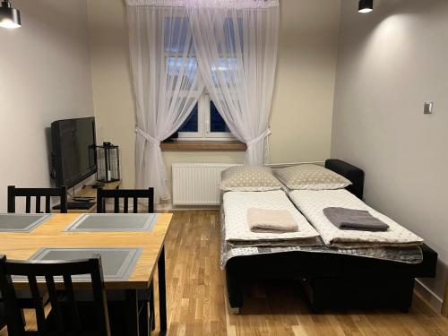 1 dormitorio con 2 camas, mesa y ventana en Apartament Zamkowy Stare Miasto, en Lublin