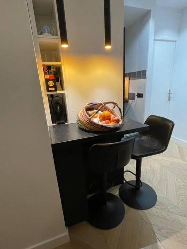 una cocina con una mesa con un bol de fruta. en Luxe Cosy appart au Parc Monceau, en París