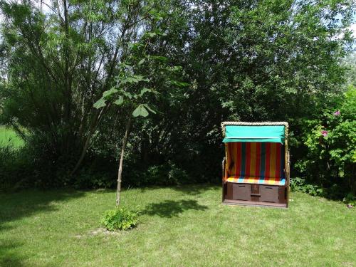 a colorful chair sitting in the grass in a yard at Westertilli 8 in Pellworm