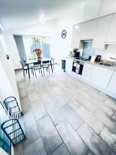 a large white kitchen with a table and chairs at 2 Bedroom Modern House in Cambridge city centre in Chesterton