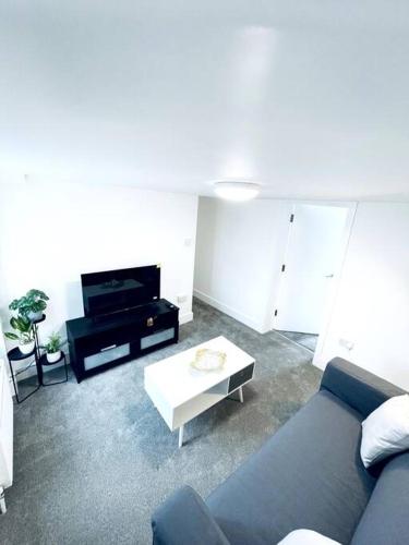 a living room with a blue couch and a table at 2 Bedroom Modern House in Cambridge city centre in Chesterton