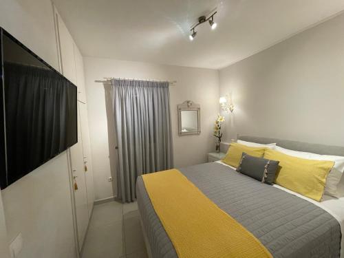 グリファダにあるBest Sea View In Glyfada Corfuのベッドルーム1室(黄色と灰色の枕が付いたベッド1台付)