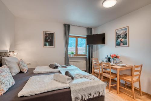 a bedroom with two beds and a dining room at Ferienwohnung Wendelstein in Kiefersfelden