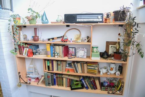 a book shelf filled with books and other items at Vila Kraljev Breg Fruška Gora Pool and Padel in Čortanovci