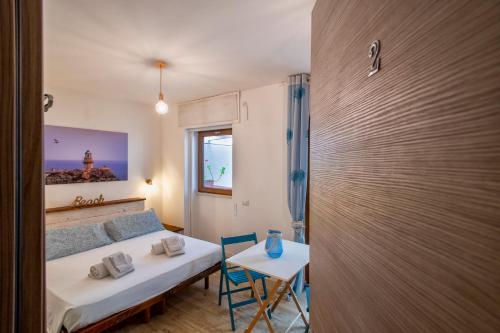 a small room with a bed and a table and a window at Dery Alghero Holiday Rooms in Alghero