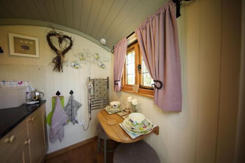 a small kitchen with a table and a window at Upper Gelli Luxury Holiday Lodge, Converted Dairy & Cosy Shepherds Huts in Welshpool