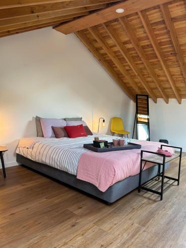 a bedroom with a large bed with a table at B&C Furnas House in Furnas
