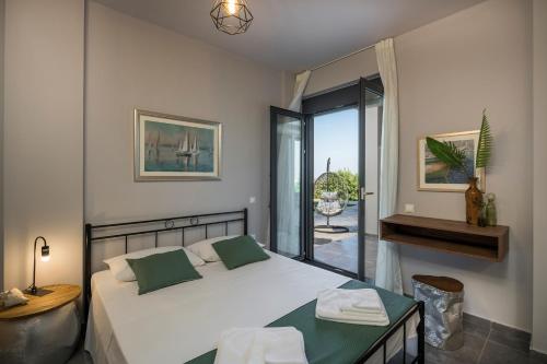 ein Schlafzimmer mit einem großen weißen Bett und einem Balkon in der Unterkunft OliveNest Chania Executive Villa in Perivólia