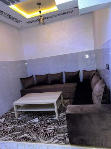 ein Wohnzimmer mit einem Sofa und einem Couchtisch in der Unterkunft Appartement Sable D'or in Tan-Tan