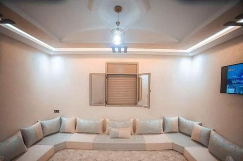ein Wohnzimmer mit einem Sofa und einem Fenster in der Unterkunft Appartement Sable D'or in Tan-Tan