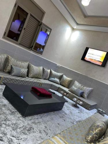 ein Wohnzimmer mit einem Sofa und einem TV in der Unterkunft Appartement Sable D'or in Tan-Tan