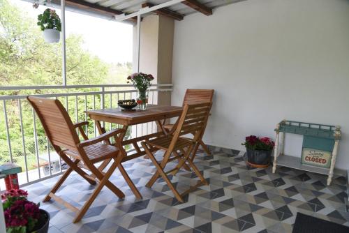 a balcony with a wooden table and two chairs at Vila Kraljev Breg Fruška Gora Pool and Padel in Čortanovci