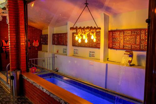 a swimming pool in a bar with a chandelier at Belljem Homes -your own private resort -1 BHK FF in Trichūr