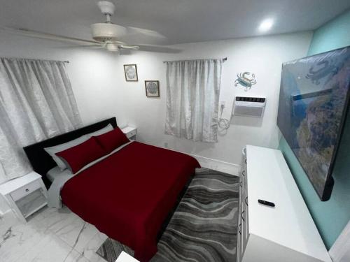 ein Schlafzimmer mit einem Bett mit einer roten Decke in der Unterkunft Seaside Studio *5 min to beach* in Fort Lauderdale