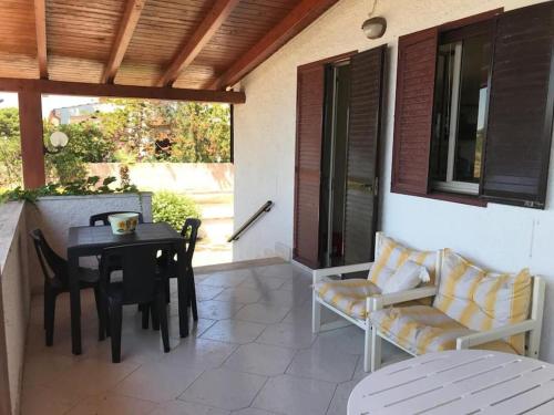 une terrasse avec une table et des chaises ainsi qu'une salle à manger dans l'établissement villa Loredana a 800 MT dal mare, à Marina di Lizzano
