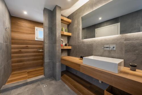 La salle de bains est pourvue d'un lavabo et d'un miroir. dans l'établissement iL Fagiolo Suites, à Vourvoúlos