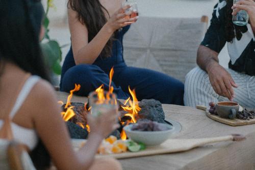 eine Gruppe von Menschen, die an einem Tisch mit Feuer sitzen in der Unterkunft Yara Hotel - Adults Only in Palm Springs
