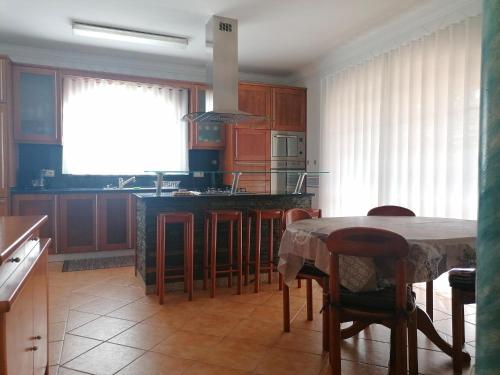 a kitchen with wooden cabinets and a table with chairs at Casa Travessa da Quinta in Mondim de Basto