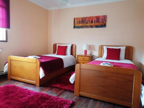 a bedroom with two beds and two rugs at Casa Travessa da Quinta in Mondim de Basto