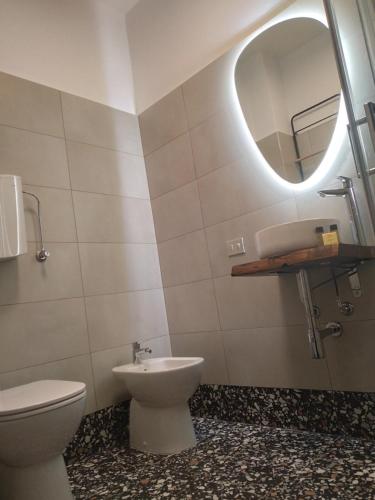 een badkamer met een toilet, een wastafel en een spiegel bij Il Borgo della Leti in Bergamo