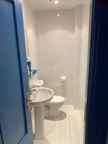 een witte badkamer met een toilet en een wastafel bij Casa helanna in El Puerto de Santa María