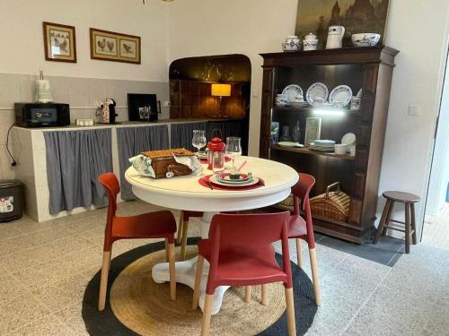 una sala da pranzo con tavolo e sedie rosse di Quinta dos Chorões a São Vicente Ferreira