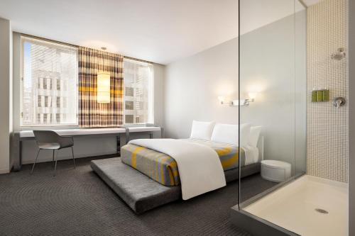 a hotel room with a bed and a desk and a tub at The Delphi Downtown LA in Los Angeles