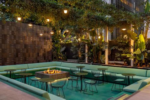 a bar with tables and chairs and a fire pit at The Delphi Hotel in Los Angeles