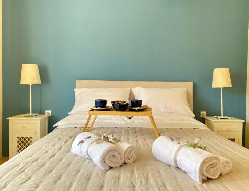 a bed with two towels and a table with two lamps at Charming Vourkari Stone Home 3 - Minutes from Port in Vourkari