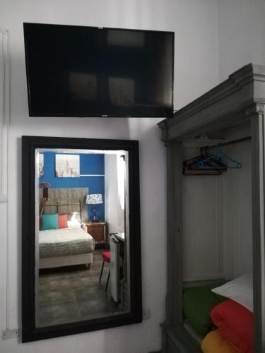 a mirror with a tv on a wall with a bedroom at HOTEL Boutique Casablanca Adrogué in Adrogué