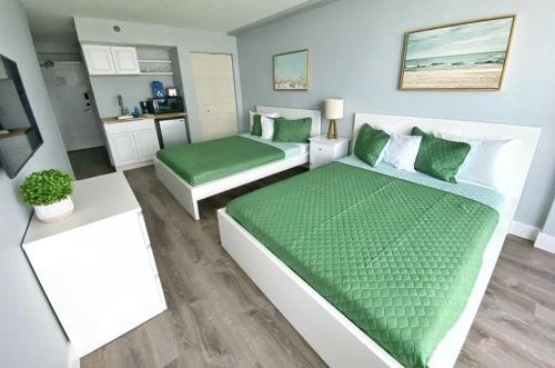 a living room with two beds and a kitchen at Ocean Side Inn Studios in Daytona Beach