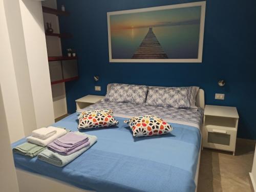 ein blaues Schlafzimmer mit einem Bett mit Kissen in der Unterkunft Il paradiso nascosto in Catania