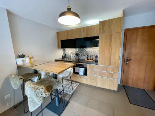 a kitchen with a wooden table and stools at Verbier Apt 2 rooms (3 guests) in Verbier