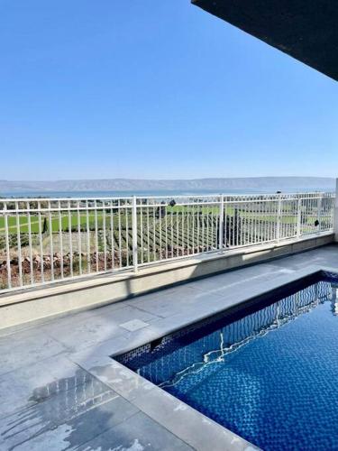 a swimming pool on a balcony with a view of the ocean at וילת רפאל in Migdal