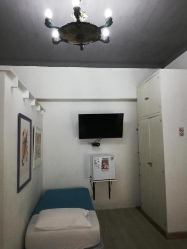 a small room with a bed and a ceiling fan at HOTEL Boutique Casablanca Adrogué in Adrogué