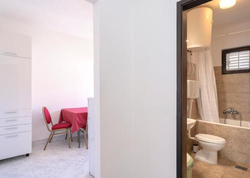 baño con mesa y silla roja en Apartments Bodlović, en Hvar