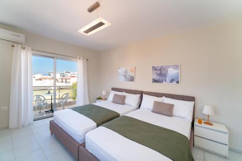 two beds in a bedroom with a balcony at Emelia Cozy Apartment in Rhodes Town