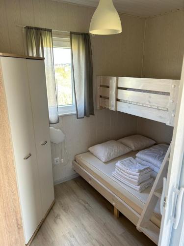 Cette petite chambre comprend des lits superposés et un placard. dans l'établissement Domki Milka, à Ustka