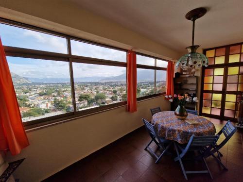 蒙德羅的住宿－Mondello Sunrise，一间带桌子和一些窗户的用餐室