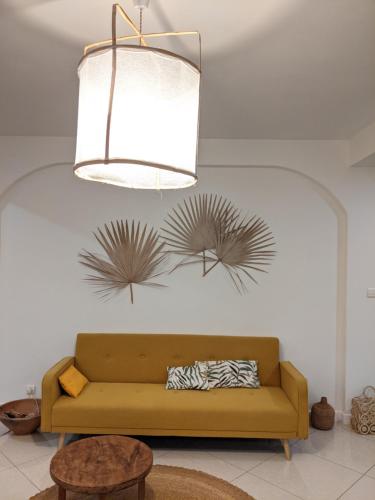 a living room with a couch and a chandelier at Appartement de charme Chez Soa in Antananarivo