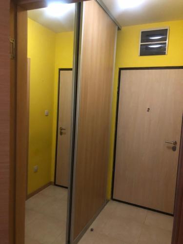 two doors in a room with yellow walls at Apartman Tanjuška in Podgorica