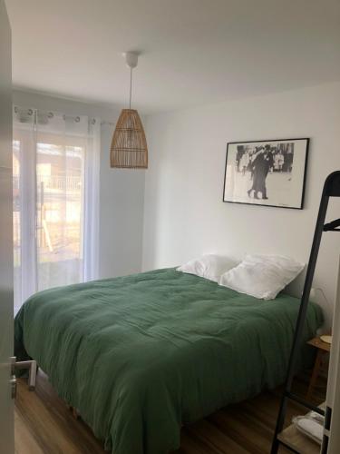 - une chambre avec un lit et une couverture verte dans l'établissement LE WIMB0 1, à Wimereux